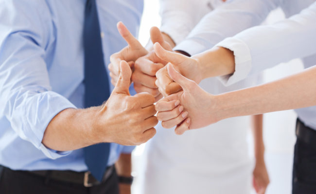 business team showing thumbs up in office